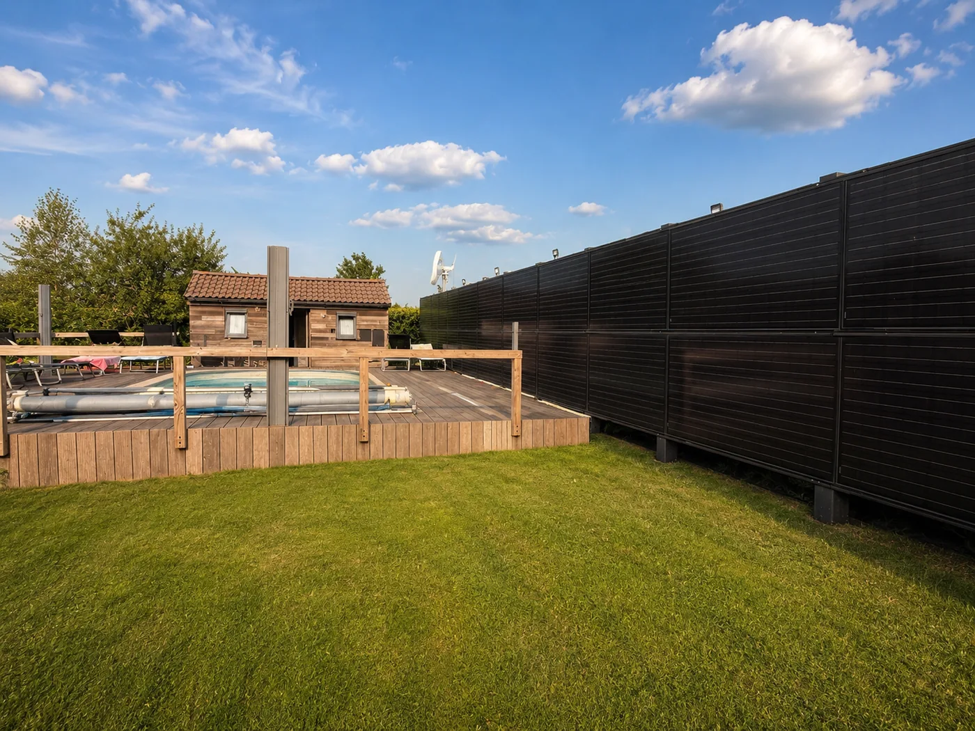Clôture de panneaux solaires verticaux entourant le jardin et la piscine