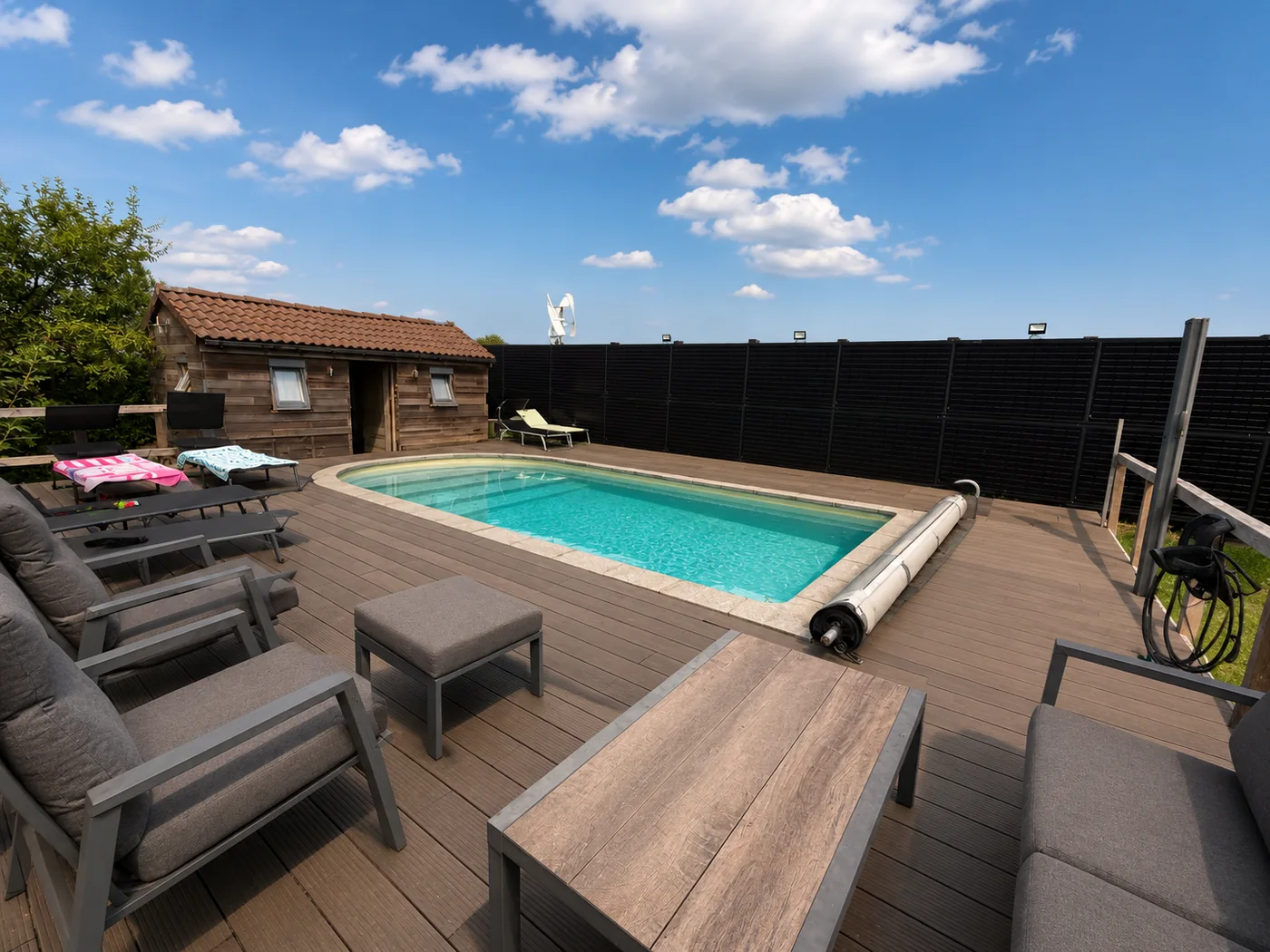 Piscine extérieure entourée d'une clôture de panneaux solaires verticaux installée par ECOCONCEPT